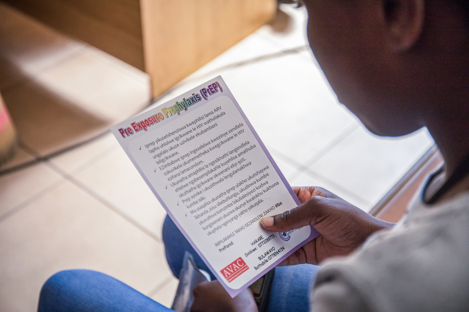 A client reads a flyer about PrEP at a clinic in Bulawayo